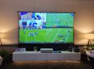 Large custom projection screen displaying multiple sports games in a modern living room.